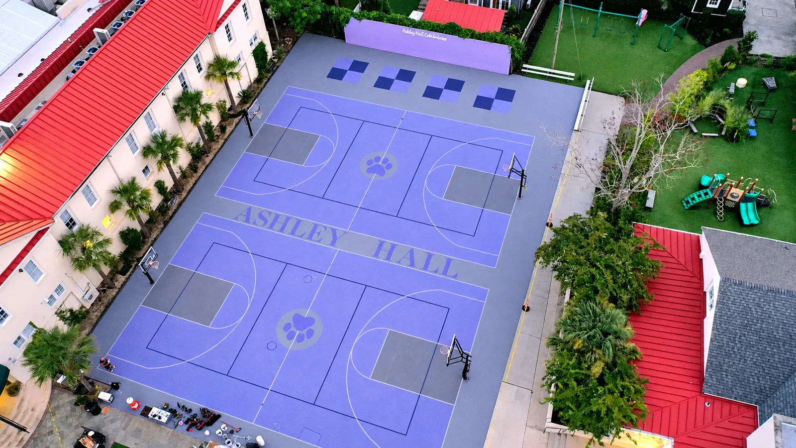 Aerial view of two purple commercial basketball courts beside a residential facility