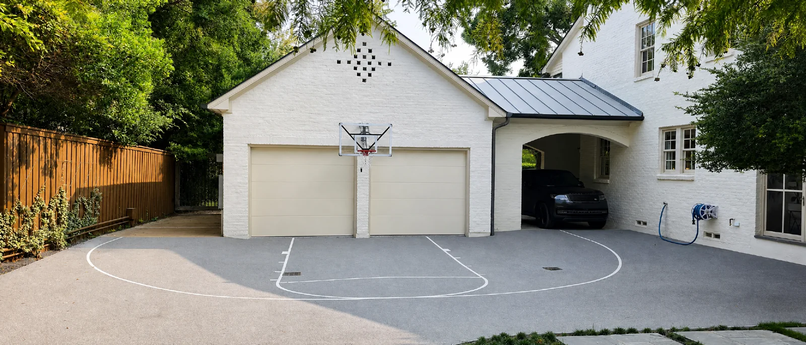 Compact grey driveway basketball court beside a residential garage